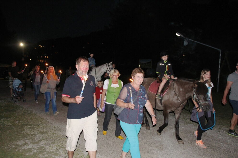 Group with torches and horse on a nocturnal excursion in the mountains.
