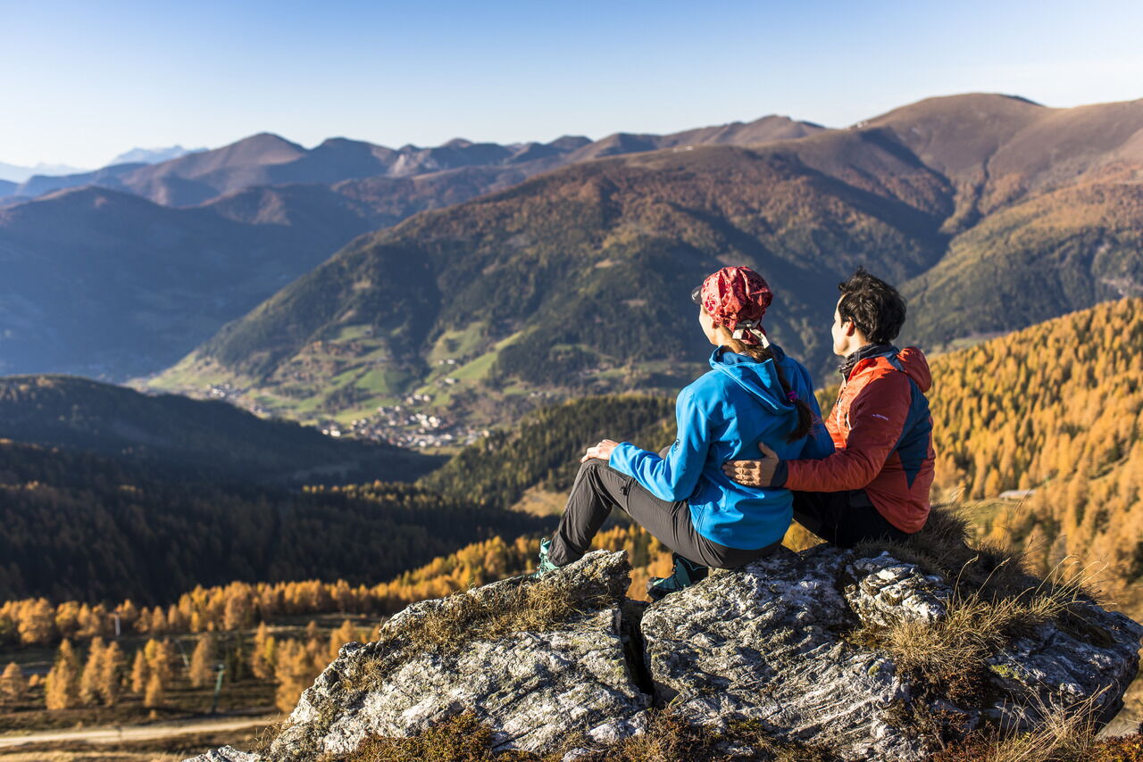 Zwei Personen genießen den Ausblick auf die sanften Hügel der Kärntner Nockberge.