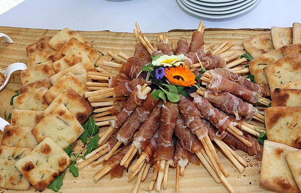 Freshly baked bread and bacon artfully arranged on a rustic wooden board.