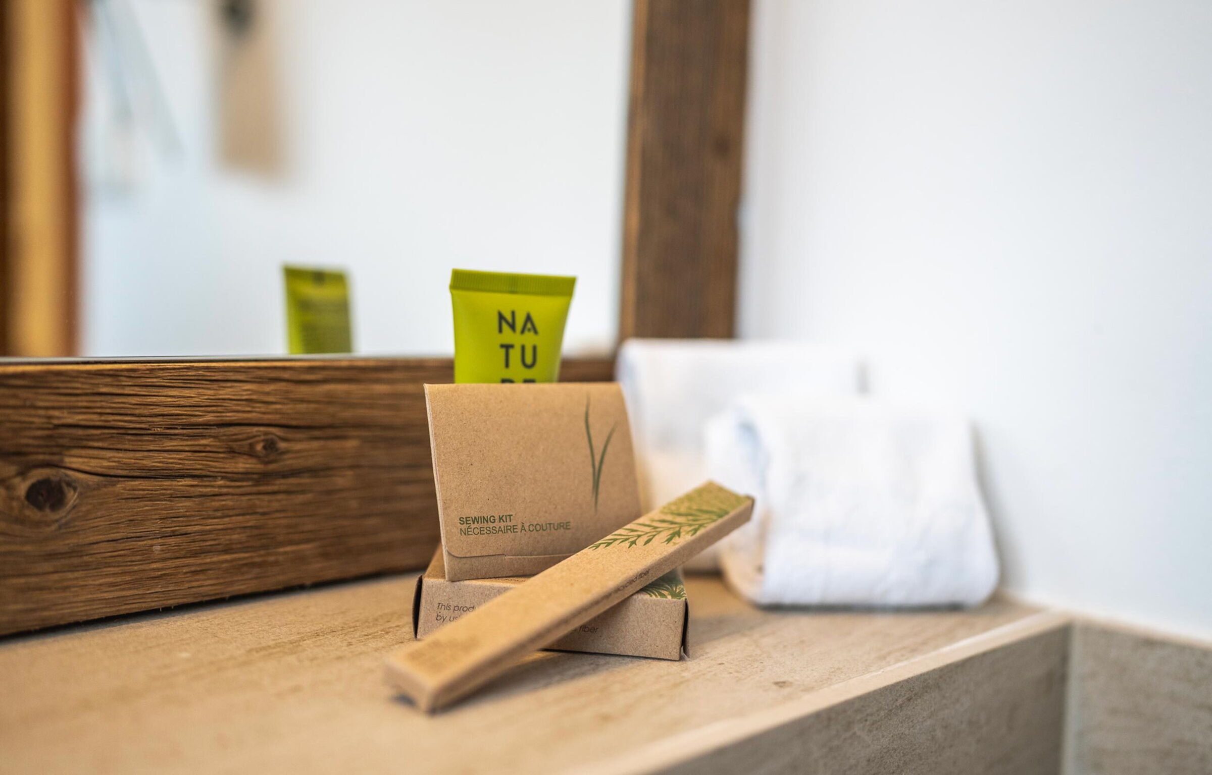 Bathroom with sustainable care products and towel on wooden shelf