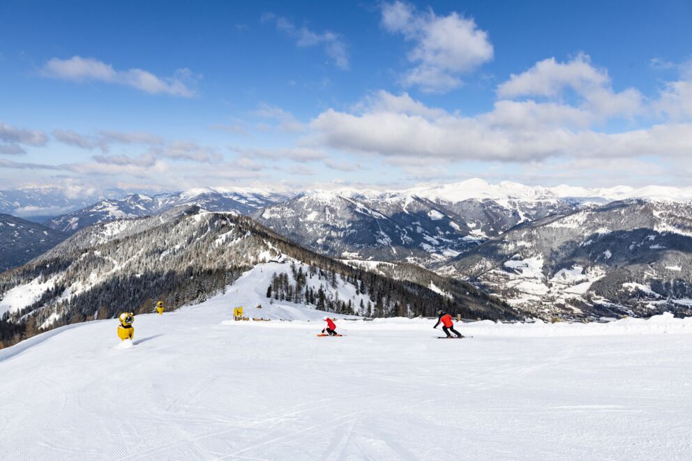 Skifahrer auf sonniger Piste mit Blick auf die malerischen Nockberge in Kärnten.