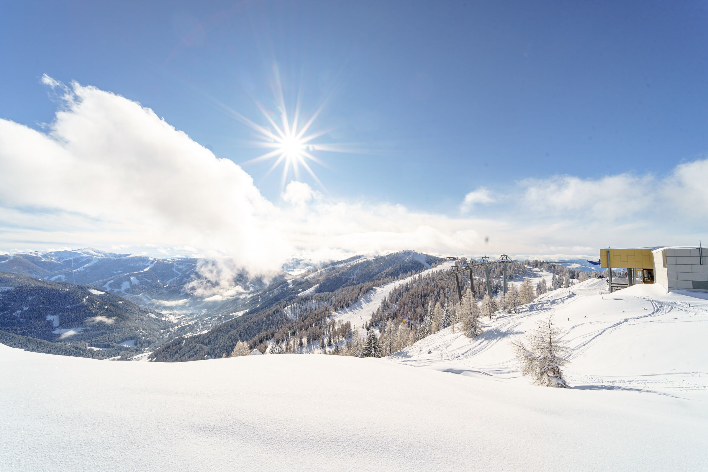 Snow-covered mountains under a bright blue sky in the Nockberge mountains.