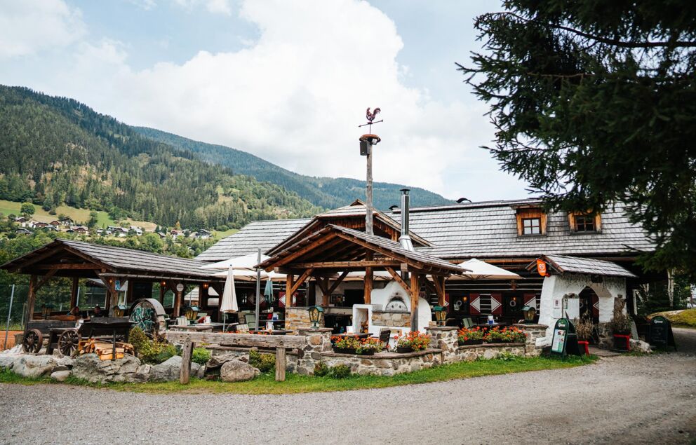 Traditionelle Hütte in den Bergen mit üppiger Vegetation und gemütlicher Atmosphäre.