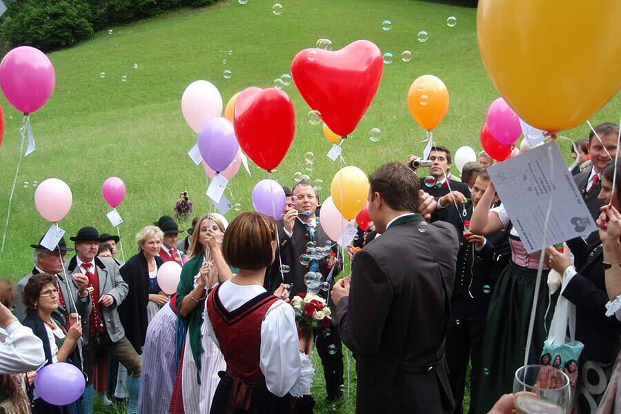 Persone in costume tradizionale con palloncini colorati su un prato