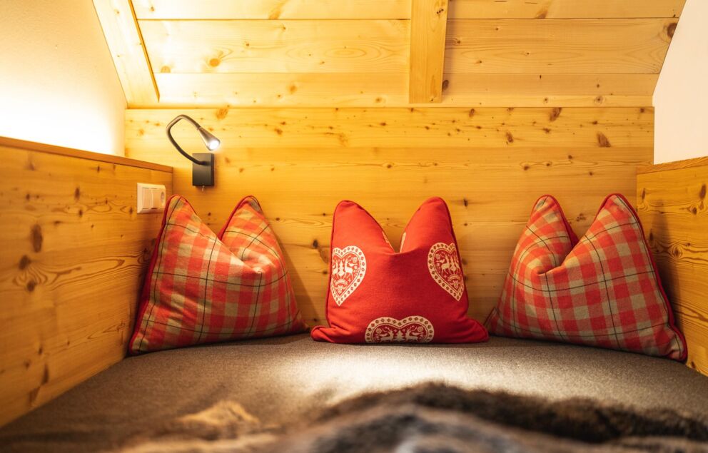 Holzwände mit roten Kissen in gemütlicher Chalet-Ecke
