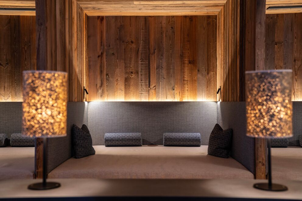 Accogliente area salotto con luci soffuse e pareti in legno rustico nello chalet.