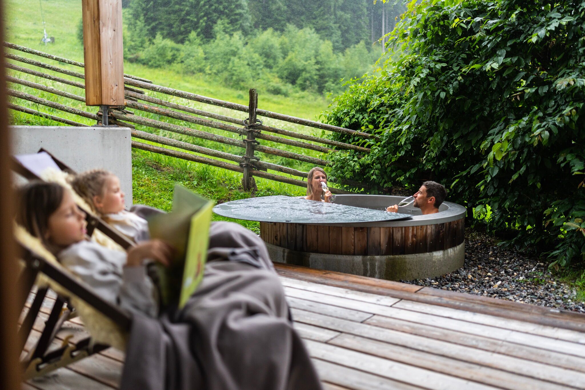Familie genießt entspannte Momente im Whirlpool mit grüner Umgebung.
