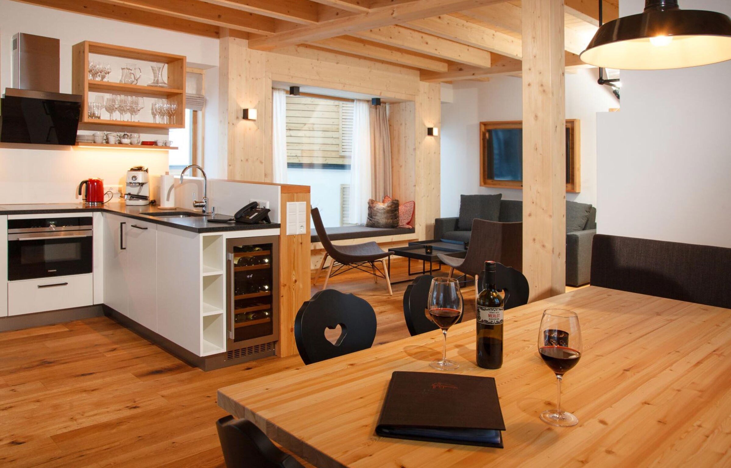 Elegante Küche und gemütlicher Wohnbereich in einem luxuriösen Chalet mit Holzelementen.