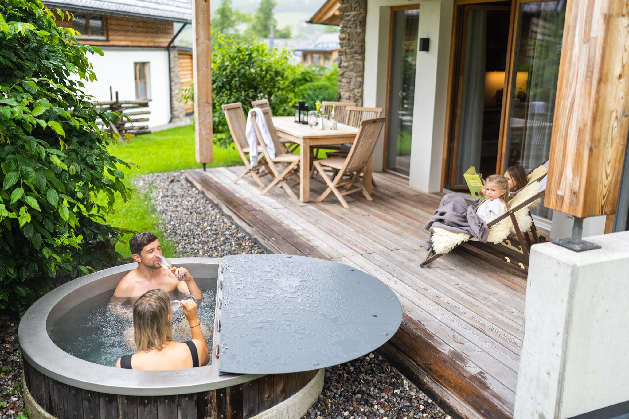 La famiglia si gode un momento di tranquillità sulla terrazza con vasca idromassaggio e accogliente area salotto.