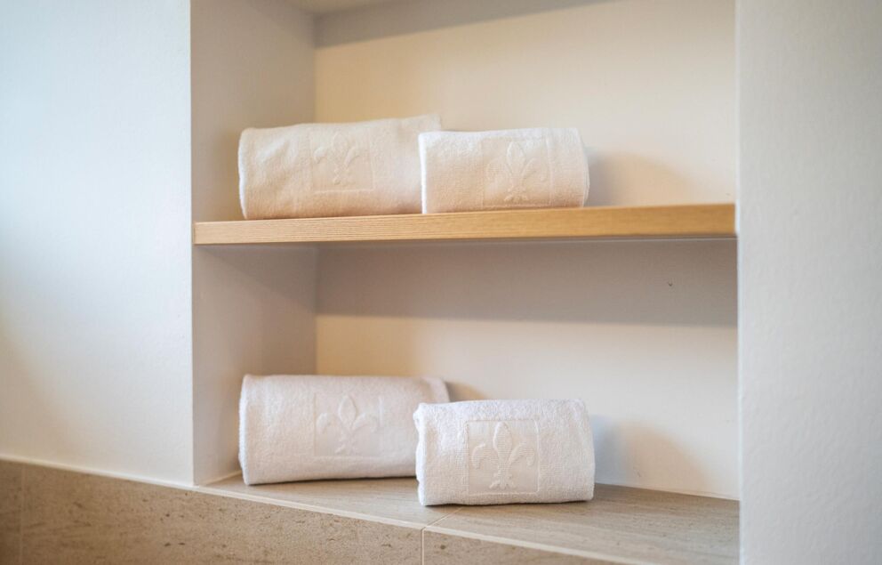 Fresh, white towels neatly stacked on shelves.