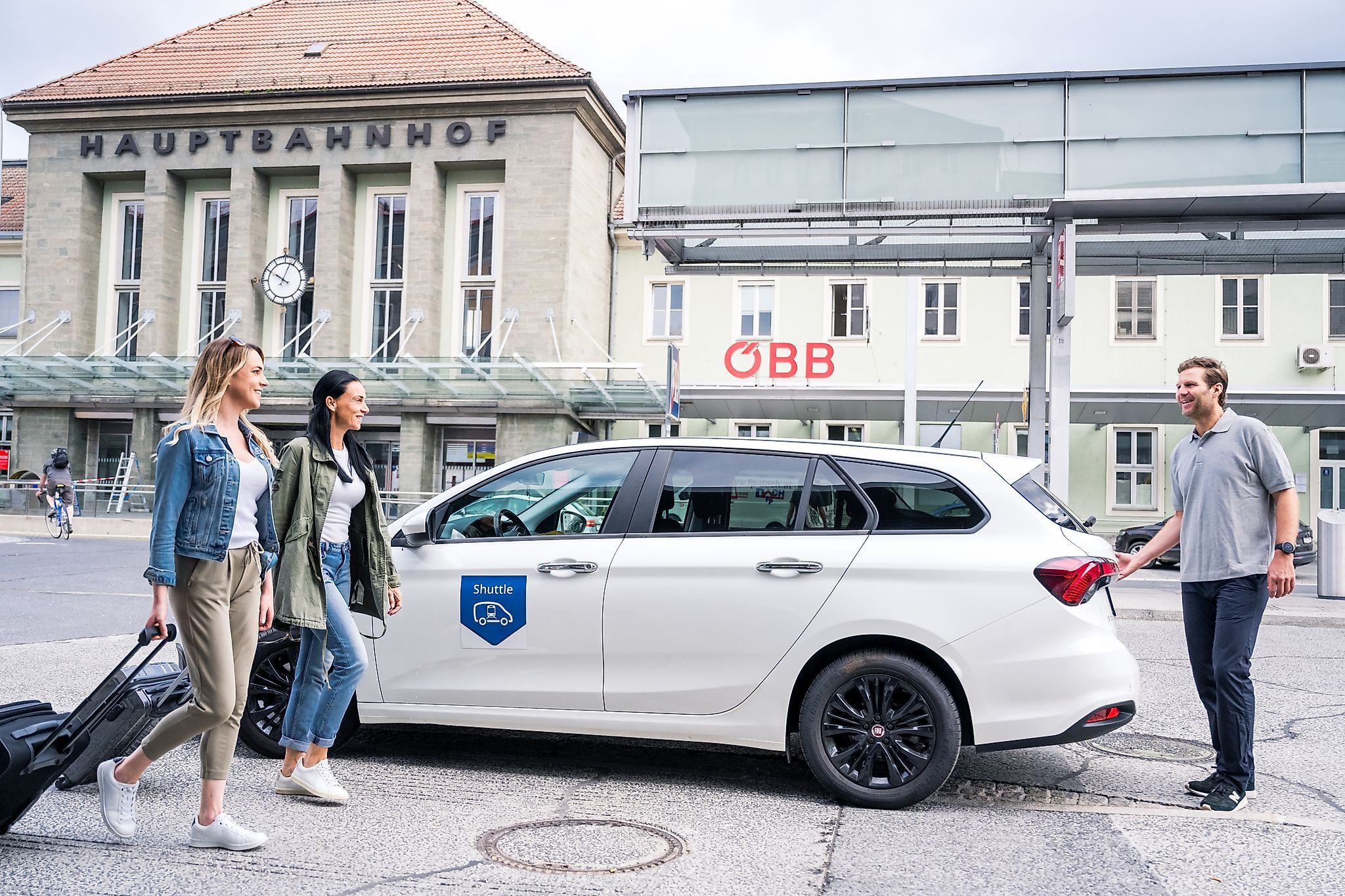 Zwei Frauen werden am Hauptbahnhof von einem Shuttle-Fahrer zu ihrem Auto begleitet.