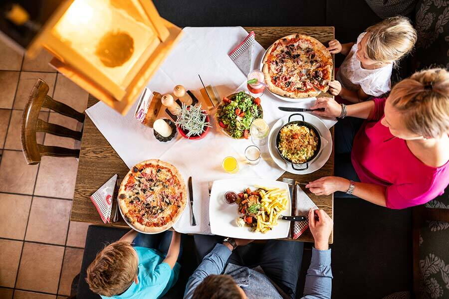 Familie genießt gemeinsam eine abwechslungsreiche Mahlzeit an einem einladend gedeckten Tisch.
