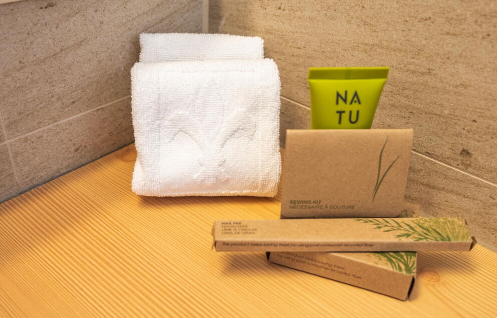 Asciugamano e cosmetici naturali su una superficie di legno nel bagno di uno chalet.