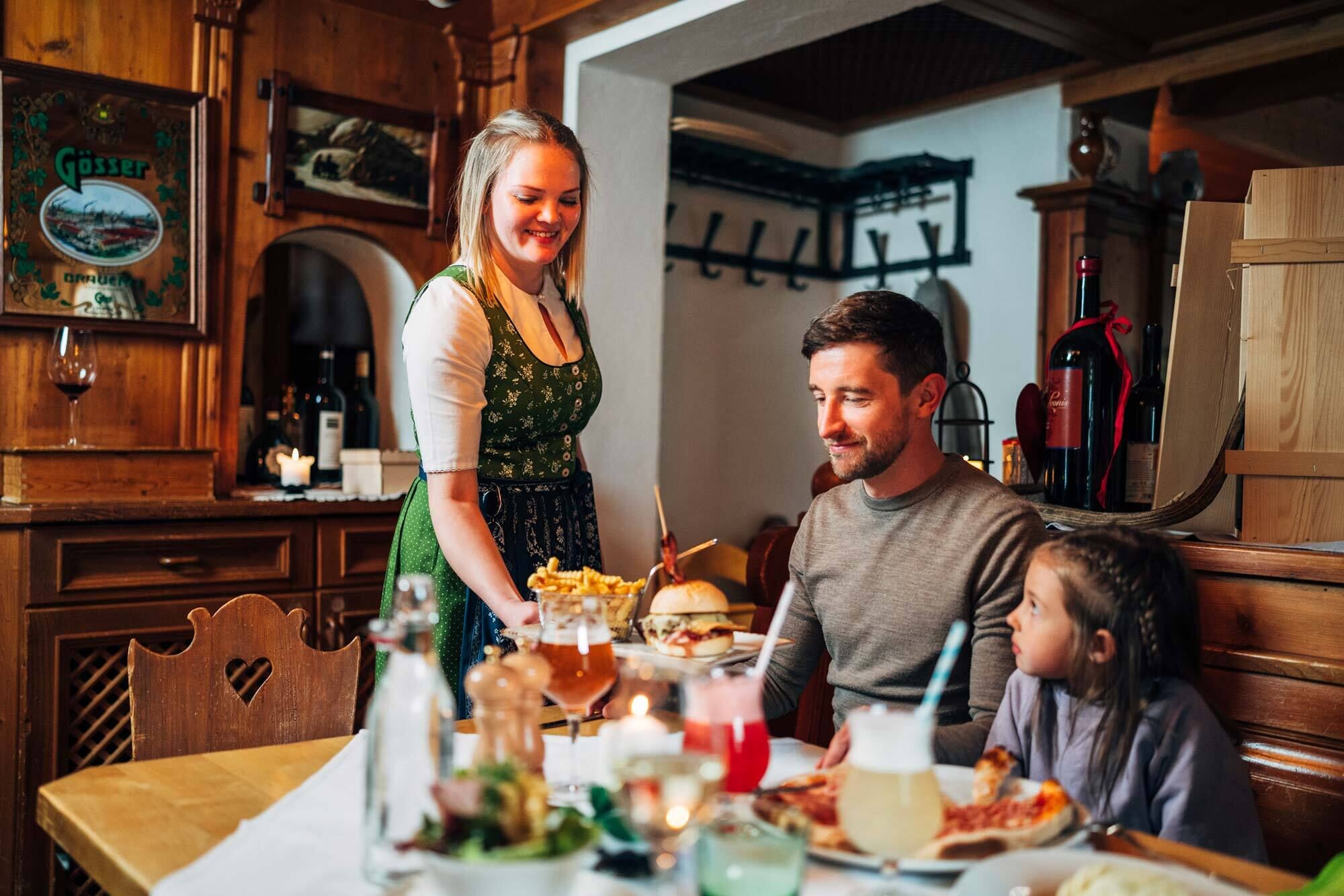 Familie genießt Abendessen in traditionellem Restaurant mit freundlicher Bedienung.