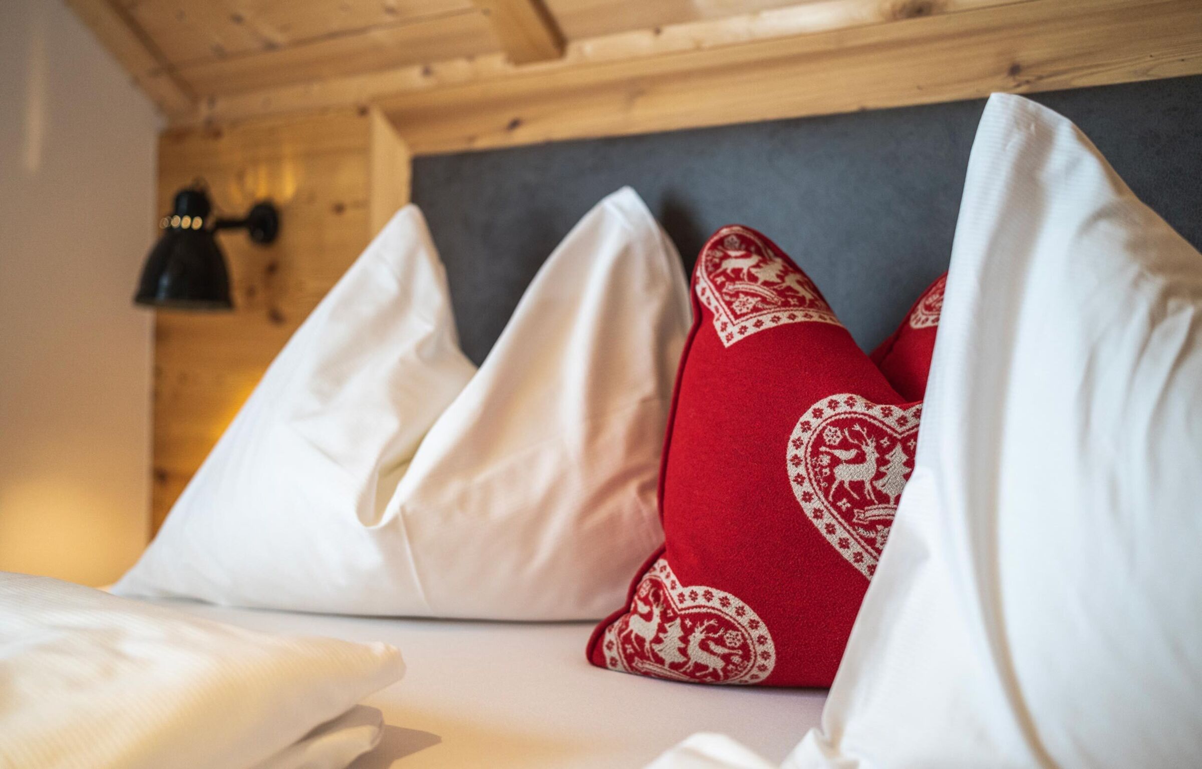 Kuschelige Kissen auf einem gemütlichen Bett im Chalet-Schlafzimmer.