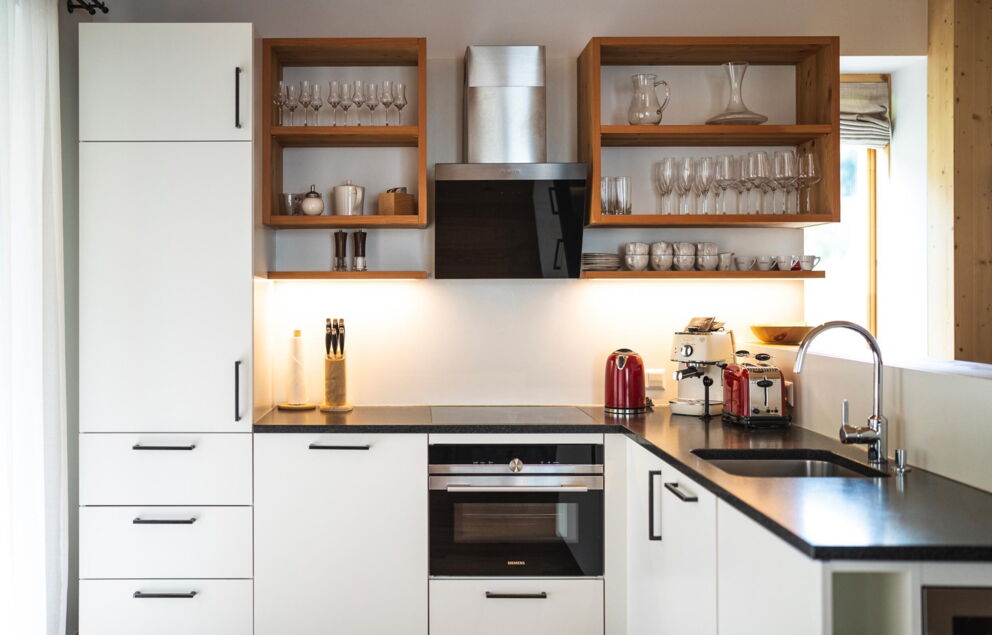 Elegante Küche mit modernen Geräten, Holzregalen und stilvollen Details im Chalet.