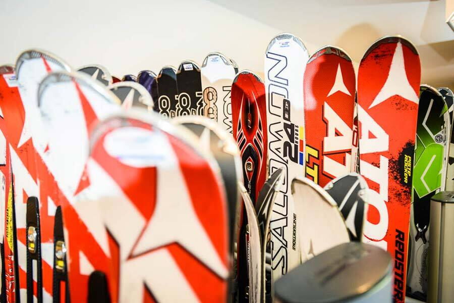 Verschiedene Skier in einem Skiverleih, bereit für den Wintersport.
