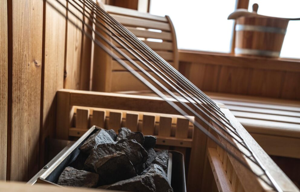 Sauna mit hölzernen Bänken und heißen Steinen für entspannende Wellness-Momente.