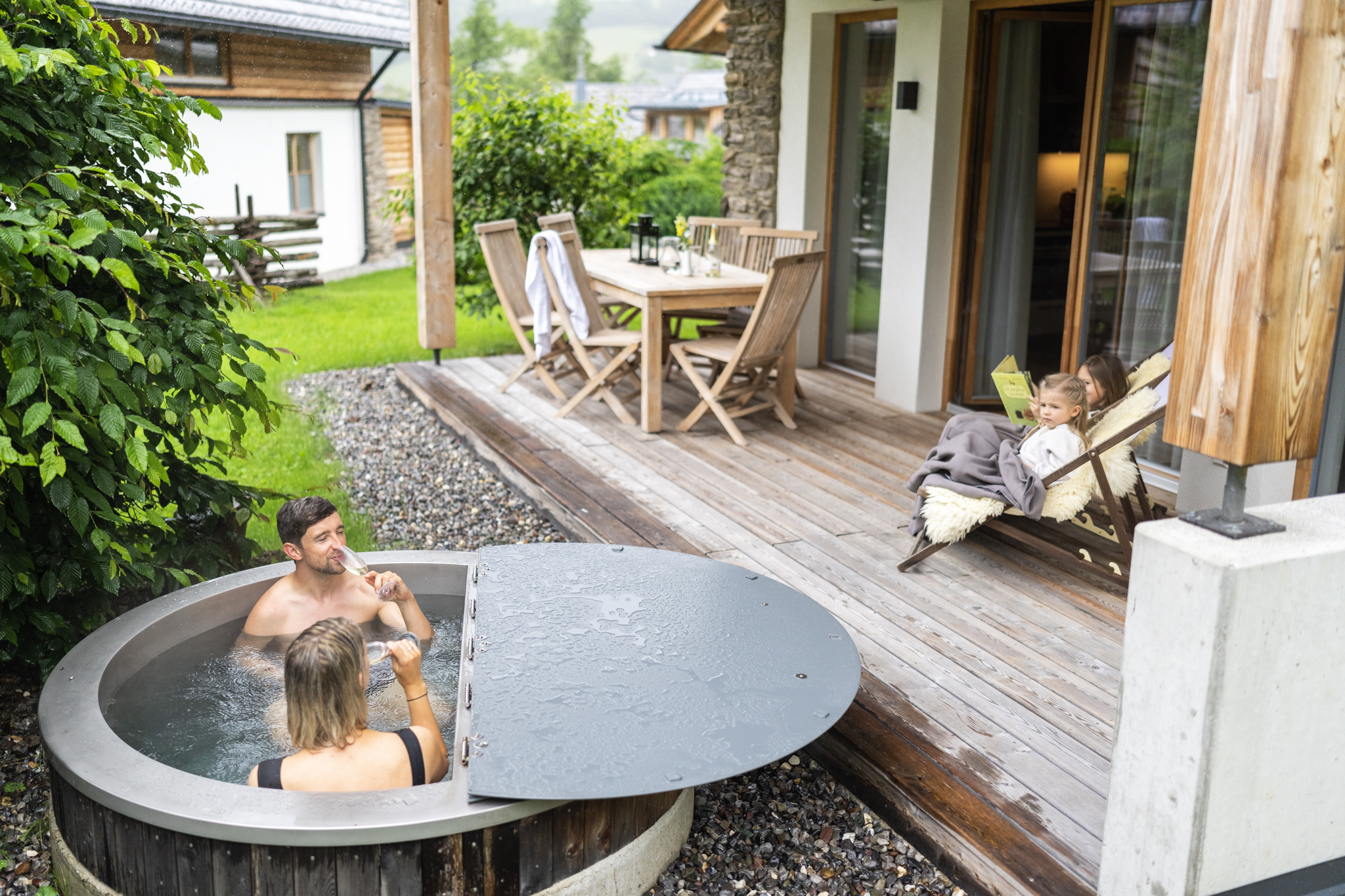 Family enjoys quiet moment on terrace with whirlpool and cozy seating area.